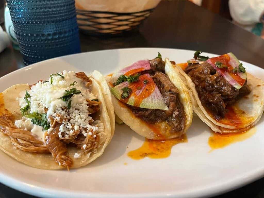 three tacos with meet and onions